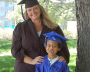 Single mother and child in graduation caps and gowns