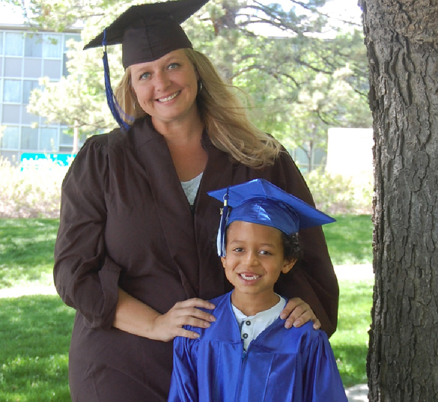Single mother and child in graduation caps and gowns