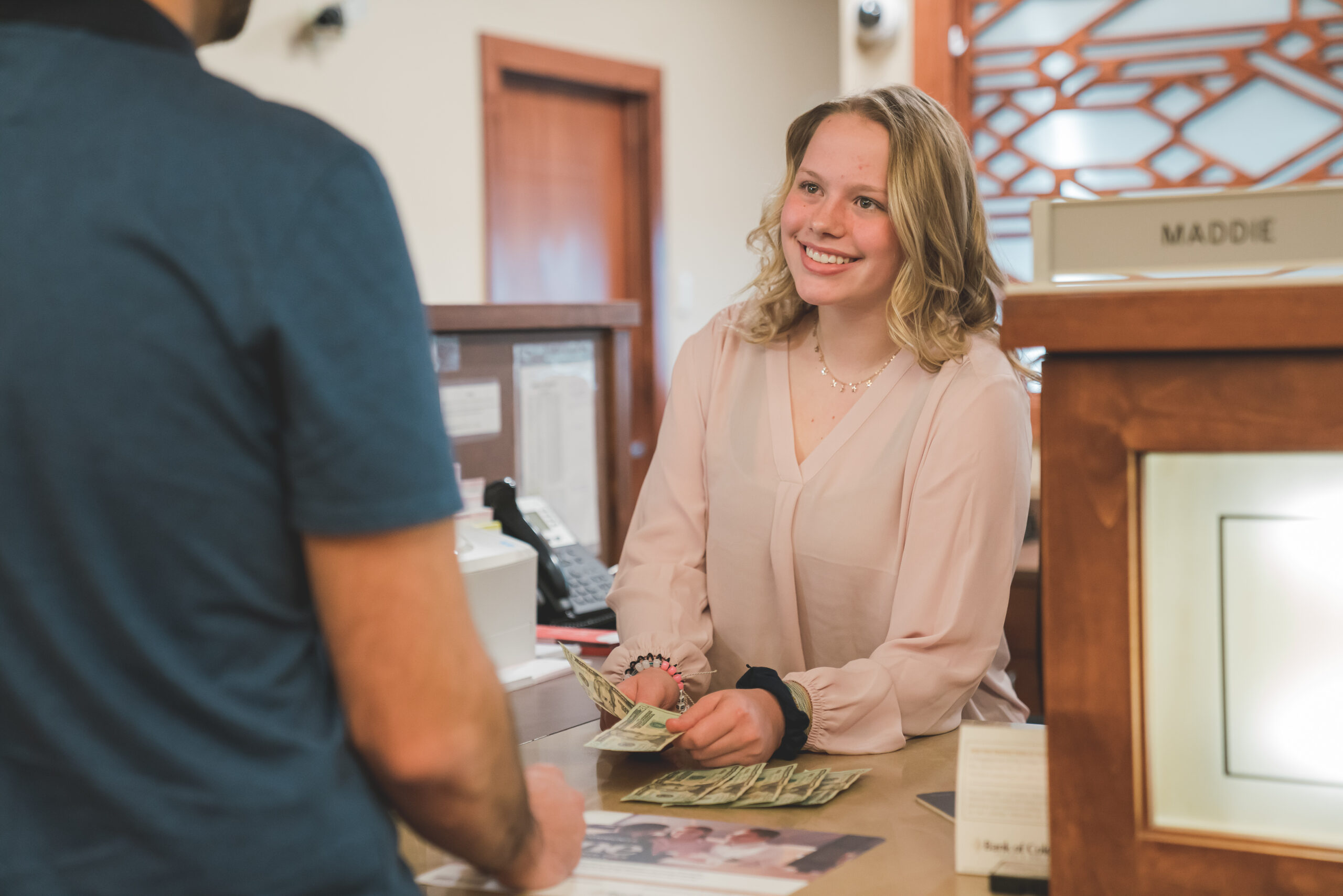 Maddie – Bank of CO Female youth apprentice from Thompson School District on the job as a Bank of Colorado cashier.
