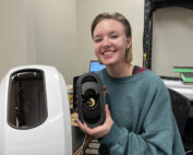 Youth female engineering intern posing with robot she built through internship at Better Process.
